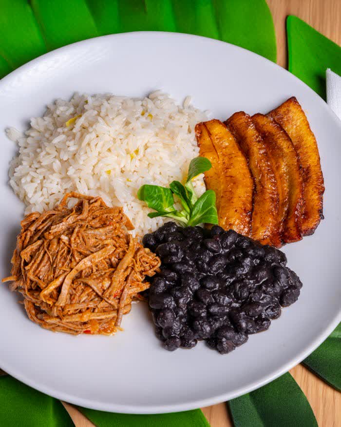 Comida típica latinoamericana con arroz, plátanos, frijoles negros y carne — restaurante familiar en Costa Rica